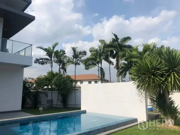 บ้าน ให้เช่าในSuan Luang, Bangkok - สระว่ายน้ำส่วนตัว รายล้อมด้วยต้นปาล์ม และตัวบ้านสมัยใหม่พร้อมระเบียงกระจก