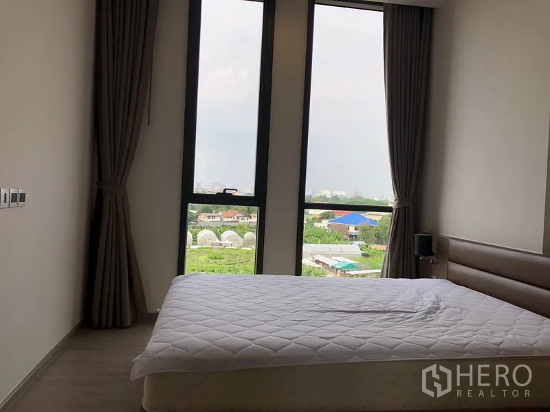 คอนโด ให้เช่าในWatthana, Bangkok - ห้องนอนอบอุ่นพร้อมหน้าต่างสูง ผ้าม่าน และวิวสวนและเมืองจาก Mori Haus