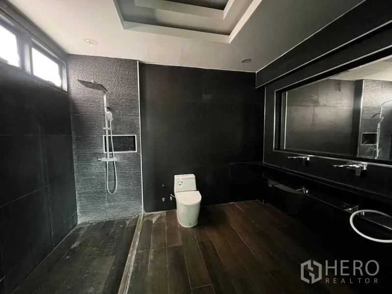 บ้าน ขายในLat Phrao, Bangkok - ห้องน้ำโทนเข้มร่วมสมัย ฝักบัวเรนชาวเวอร์ เคาน์เตอร์ยาว และกระจกบานใหญ่