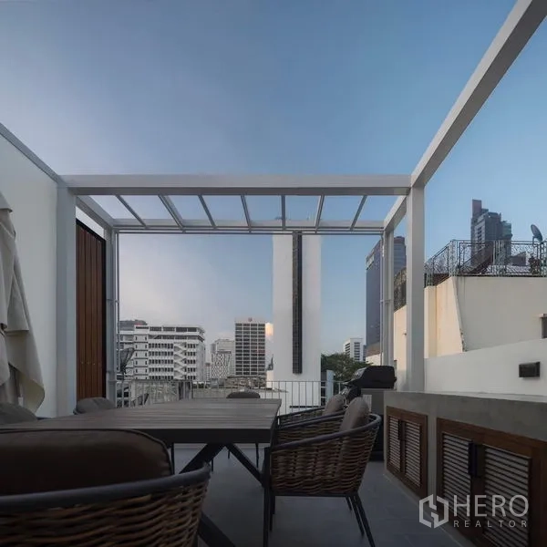 Detached House for rent in Bang Rak, Bangkok - Rooftop terrace with pergola, dining set and city views.
