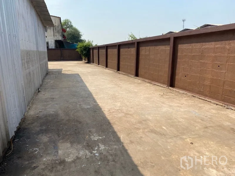 工厂 出租在Lat Lum Kaeo, Pathum Thani - 沿围墙的长条混凝土院道，便于卡车通行。