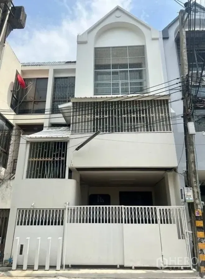ทาวน์เฮาส์ ขายในKhlong Toei, Bangkok - ทาวน์เฮ้าส์ 3 ชั้น สีขาว ด้านหน้า มีที่จอดรถในรั้ว หน้าต่างเหล็กดัด และระเบียง ใกล้ย่านสุขุมวิท