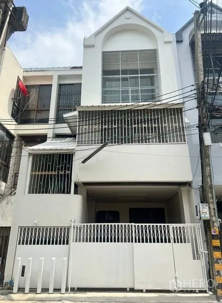 ทาวน์เฮาส์ ขายในKhlong Toei, Bangkok - ทาวน์เฮ้าส์ 3 ชั้น สีขาว ด้านหน้า มีที่จอดรถในรั้ว หน้าต่างเหล็กดัด และระเบียง ใกล้ย่านสุขุมวิท