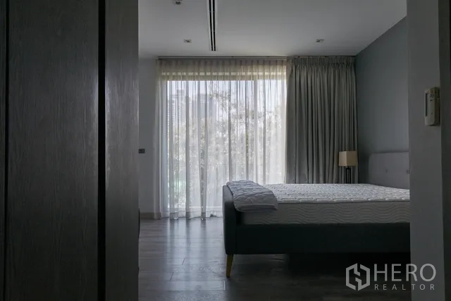 联排别墅 出租在Watthana, Bangkok - 楼上卧室，轻薄纱帘与阳台采光。