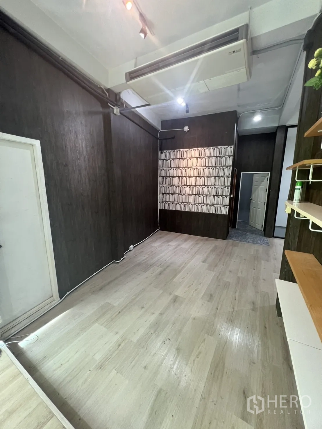 零售空间 出租在Watthana, Bangkok - 狭长展示间，吊顶空调、墙面置物架与浅色地板。