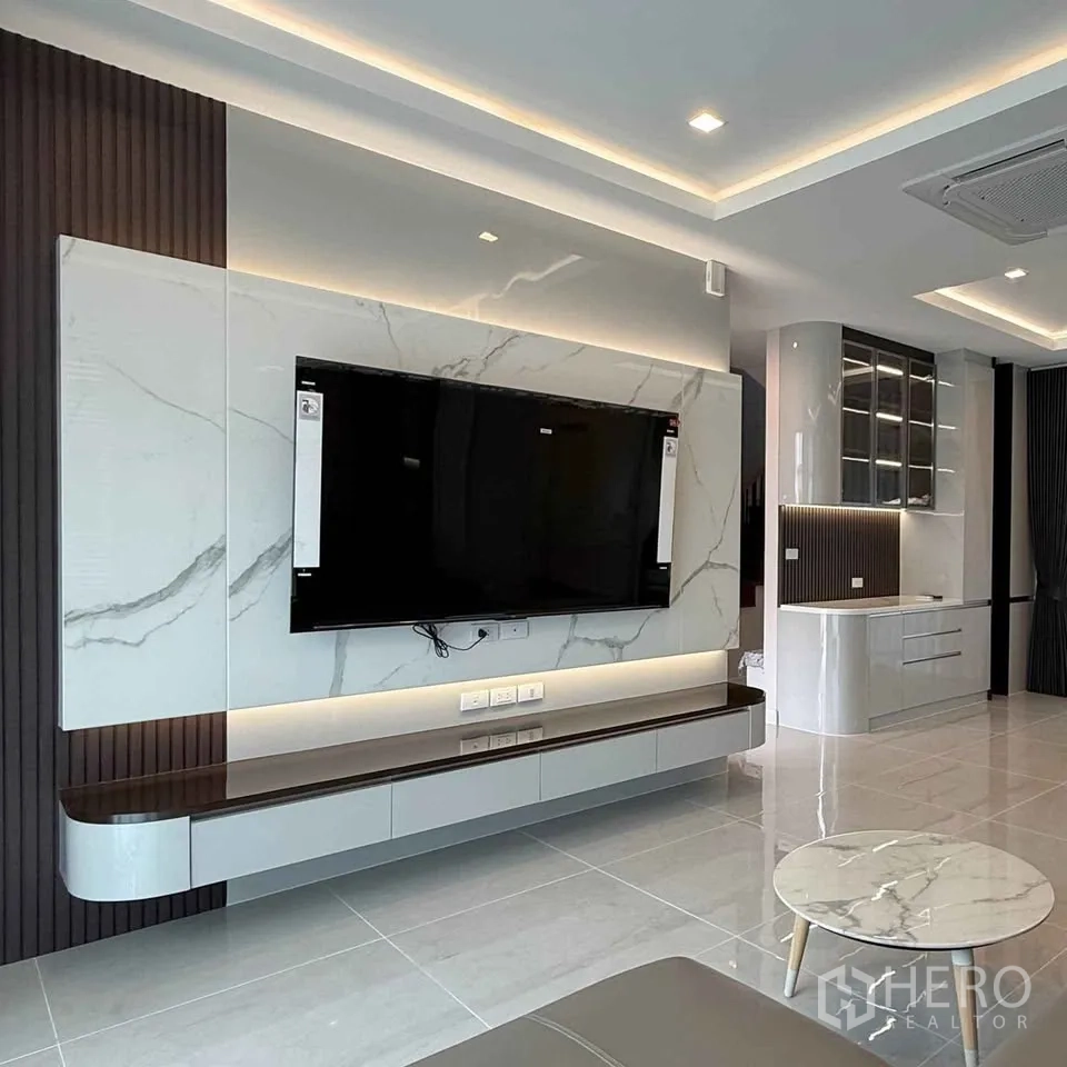 Detached House for rent in Bang Phli, Samut Prakan - TV feature wall with marble panels and floating console in the lounge.