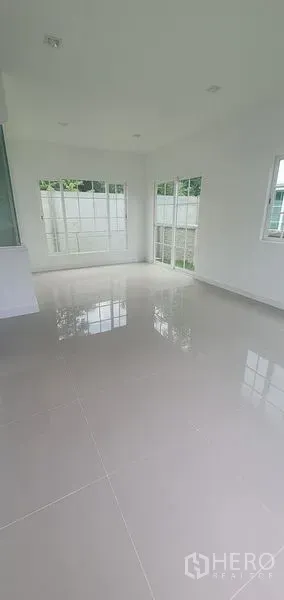 Detached House for rent in Nonthaburi - Sunlit corner of the living space with large windows and garden access in Pak Kret, Nonthaburi.