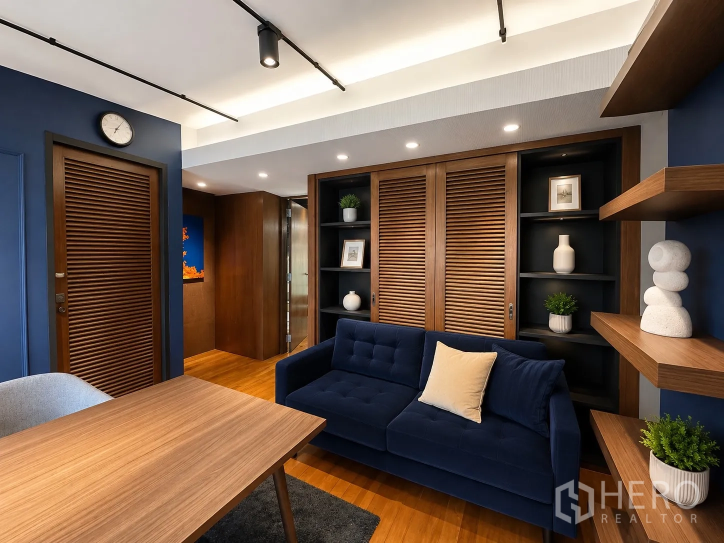 办公室 for rent in Phaya Thai, Bangkok - 休闲接待区，海军蓝沙发、木质书架与柜体。