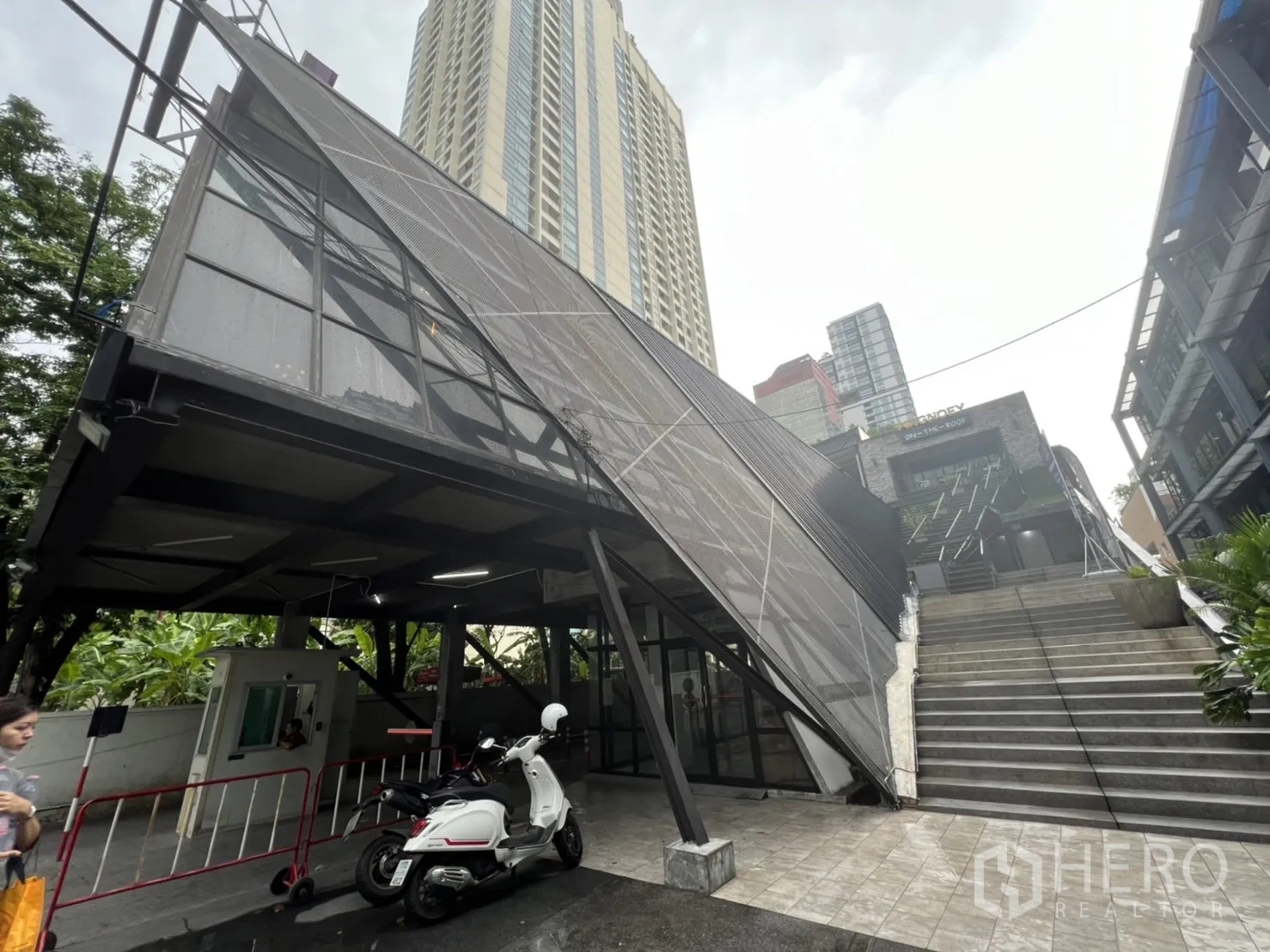 零售空间 出租在Ratchathewi, Bangkok - 入口广场，倾斜钢质立面与宽阔台阶，周围高楼林立