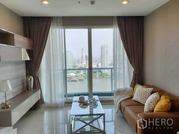 Condominium for rent in Bang Kho Laem, Bangkok - Bright living room with floor-to-ceiling windows and Chao Phraya River view.