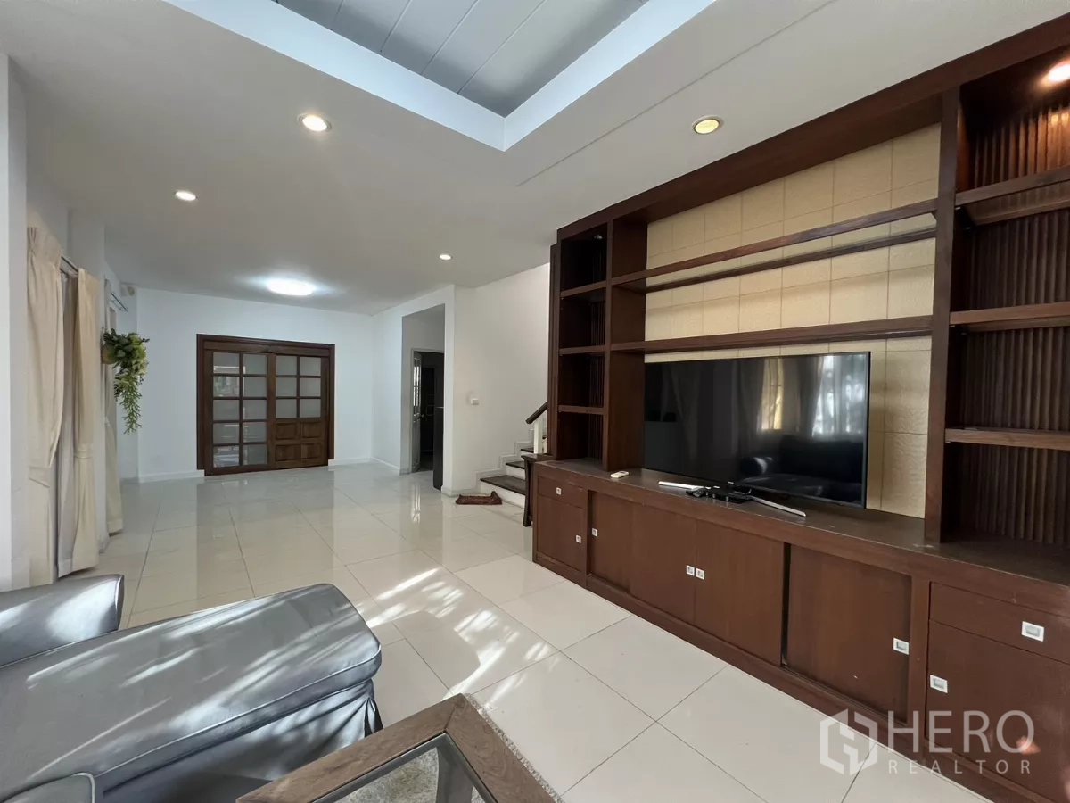 Detached House for rent in Bang Kapi, Bangkok - Built-in entertainment cabinetry and sliding wooden doors in the living room.