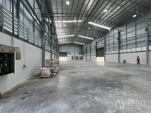 货栈 出租在Bang Sao Thong, Samut Prakan - 仓库内部通透，高挑钢桁架与抛光混凝土地面。