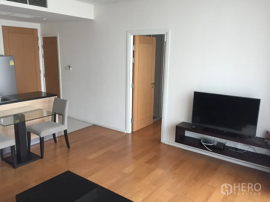 คอนโด ให้เช่าหรือขายในWatthana, Bangkok - ห้องนั่งเล่นแบบโอเพ่นพร้อมพื้นไม้ ชั้นวางทีวี และมุมทานอาหารข้างครัว