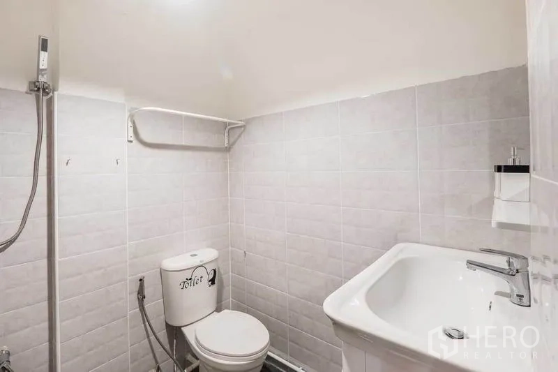 บ้าน ให้เช่าในKhlong Toei, Bangkok - ห้องน้ำกระเบื้องสีขาวกะทัดรัด พร้อมฝักบัว โถสุขภัณฑ์ และอ่างล้างหน้า