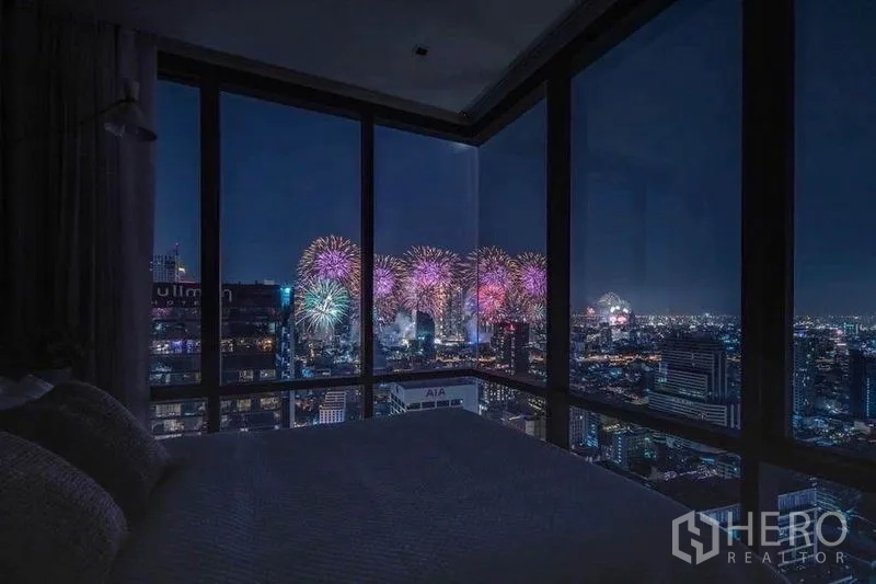 公寓 出租在Bang Rak, Bangkok - 转角卧室，落地窗外夜景与绚丽烟花一览无余。