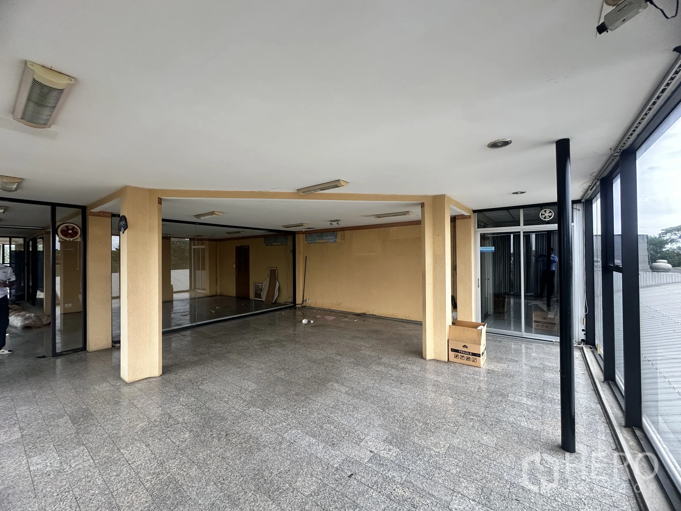 Factory for sale in Bang Bua Thong, Nonthaburi - Open-plan office floor with columns, glass partitions, and sliding doors.