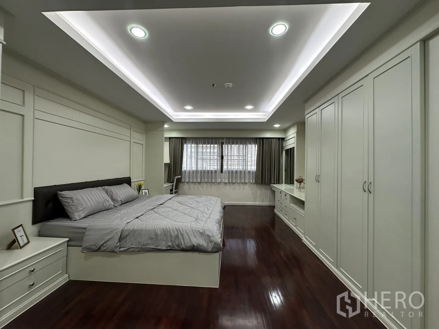 Condominium for rent in Watthana, Bangkok - Spacious master bedroom with extensive closets and polished wooden floors.