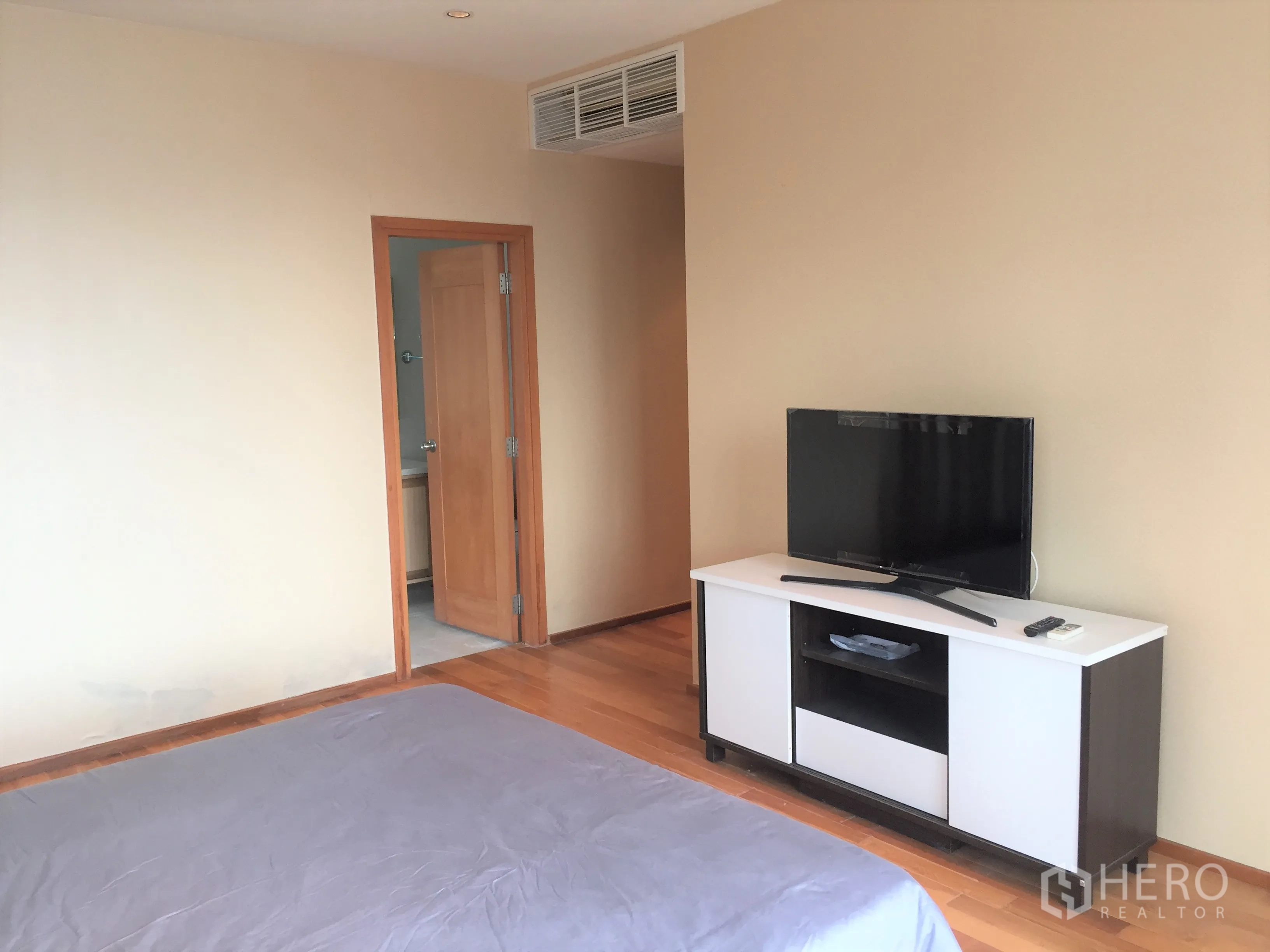 คอนโด ให้เช่าหรือขายในKhlong Toei, Bangkok - ห้องนอนใหญ่พร้อมชั้นวางทีวี พื้นไม้ และประตูเชื่อมเข้าห้องน้ำในตัว