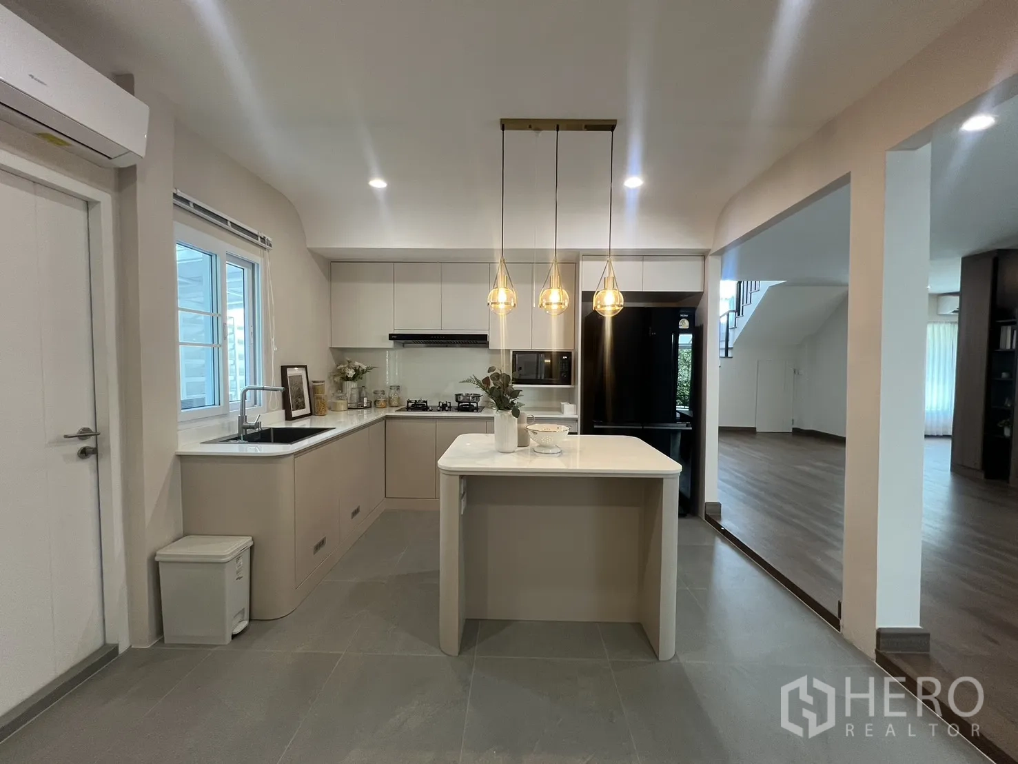 独立式住宅 出租在Mueang Samut Prakan, Samut Prakan - 厨房中岛，黑色冰箱与浅色橱柜。