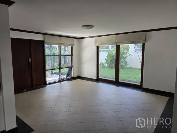 บ้าน ให้เช่าในWatthana, Bangkok - ห้องนั่งเล่นสว่าง พื้นกระเบื้อง และประตูกระจกบานเลื่อนมองเห็นสวน