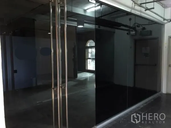 Office Space for rent in Watthana, Bangkok - Glass-fronted office entrance with double doors and exposed ceiling.