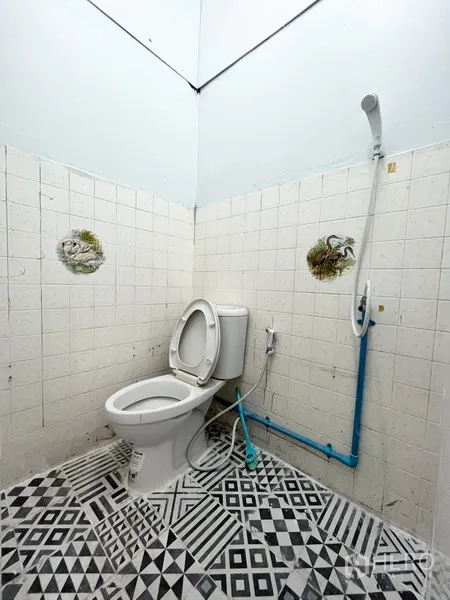 Warehouse for rent in Wang Thonglang, Bangkok - Second bathroom with toilet, wall-mounted shower, and black-and-white geometric tiles.
