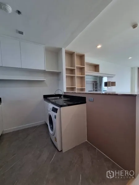 คอนโด ให้เช่าในWatthana, Bangkok - มุมครัวพร้อมเครื่องซักผ้าและชั้นเก็บของข้างเคาน์เตอร์บาร์