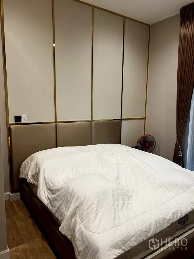 Detached House for rent or sale in Prawet, Bangkok - Bedroom with padded wall panels and warm wood-look flooring.