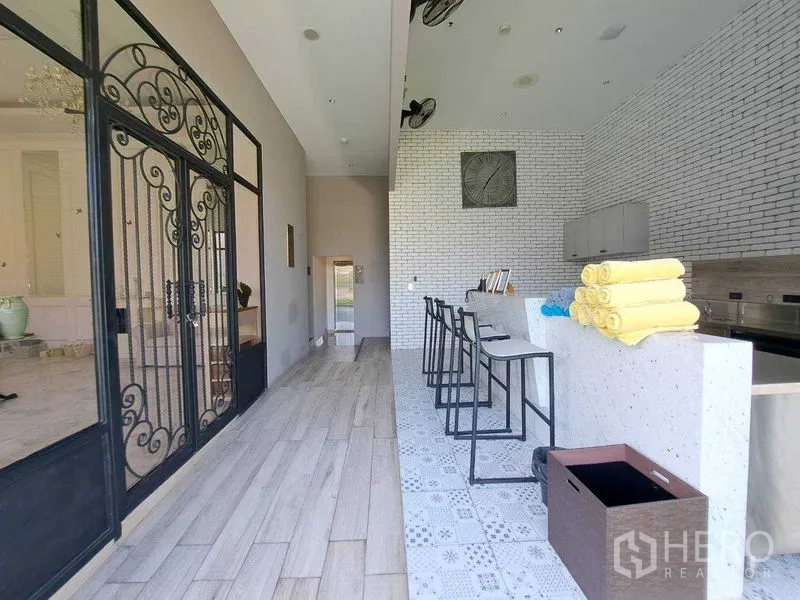 พื้นที่ขายปลีก ให้เช่าในWatthana, Bangkok - เคาน์เตอร์บาร์พร้อมสตูล ประตูเหล็กดัด และผนังก่ออิฐสีขาว