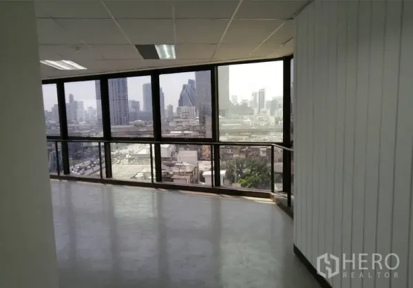 办公空间 出租在Pathum Wan, Bangkok - 转角办公室，环景落地窗、吊顶与曼谷天际线景观。