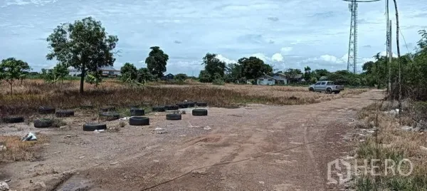 Land for sale in Bang Sao Thong, Samut Prakan - Eight-meter-wide dirt access road across the plot, with a pickup truck and tires marking the boundary.