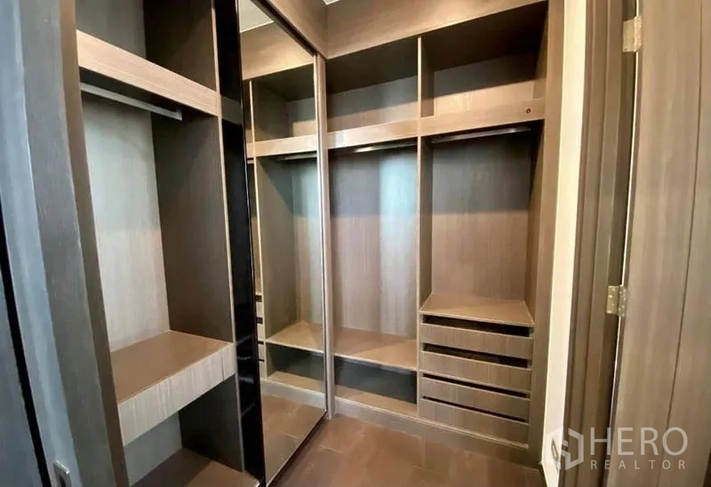 Condominium for rent in Watthana, Bangkok - Built-in walk-in closet with open shelves, drawers and a mirrored sliding door.