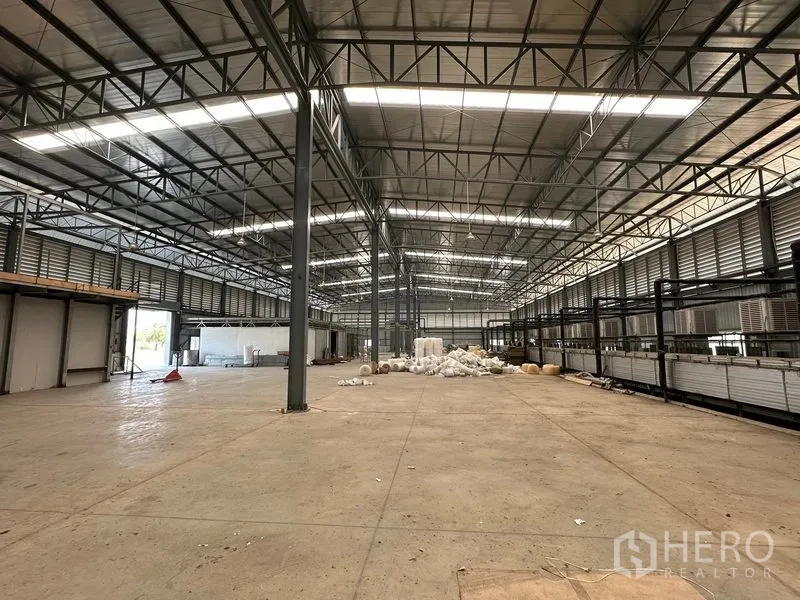 工厂 出售在Phra Nakhon Si Ayutthaya - 开放式生产区，远端有卷闸门与堆放的物料。