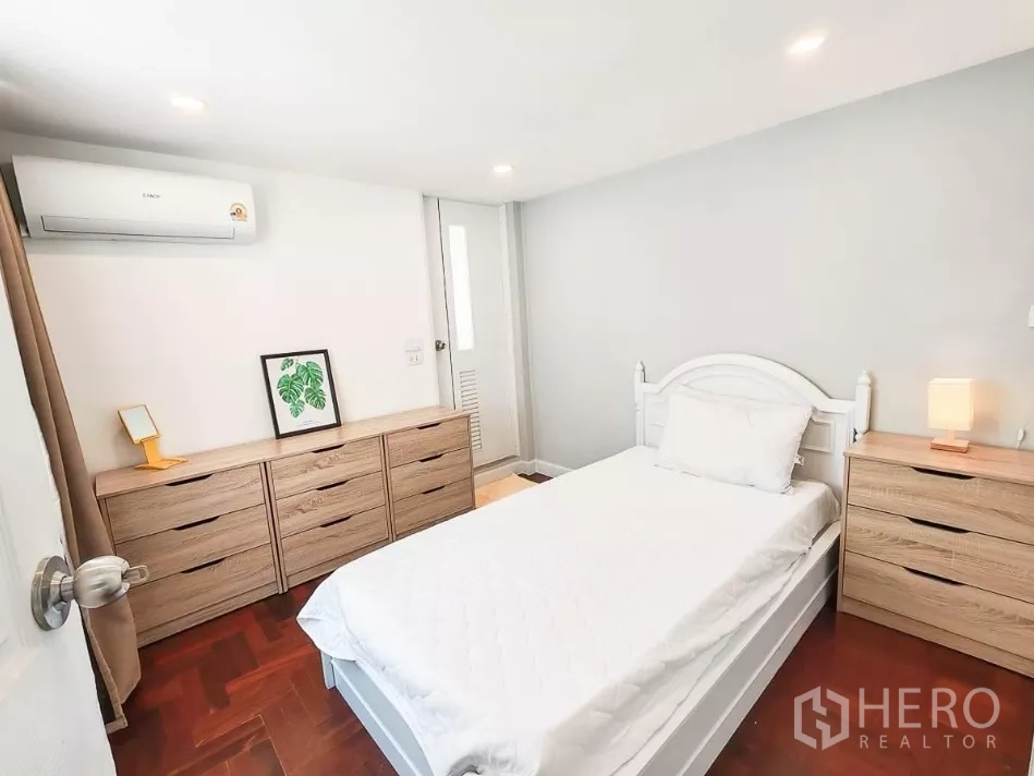 บ้าน ให้เช่าในYan Nawa, Bangkok - ห้องนอนแขกสว่าง เตียงสีขาว ตู้ลิ้นชักไม้ และเครื่องปรับอากาศ