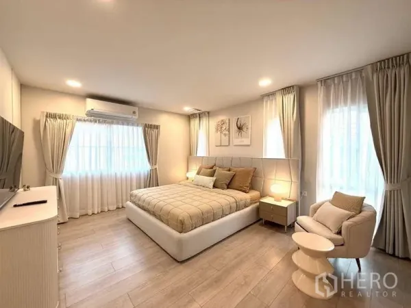 Detached House for rent in Bang Phli, Samut Prakan - Spacious master bedroom with king bed, armchair and soft drapes.