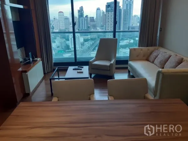 公寓 出租或出售在Khlong Toei, Bangkok - 客厅设落地窗与曼谷天际线景观，木地板，沙发与扶手椅。