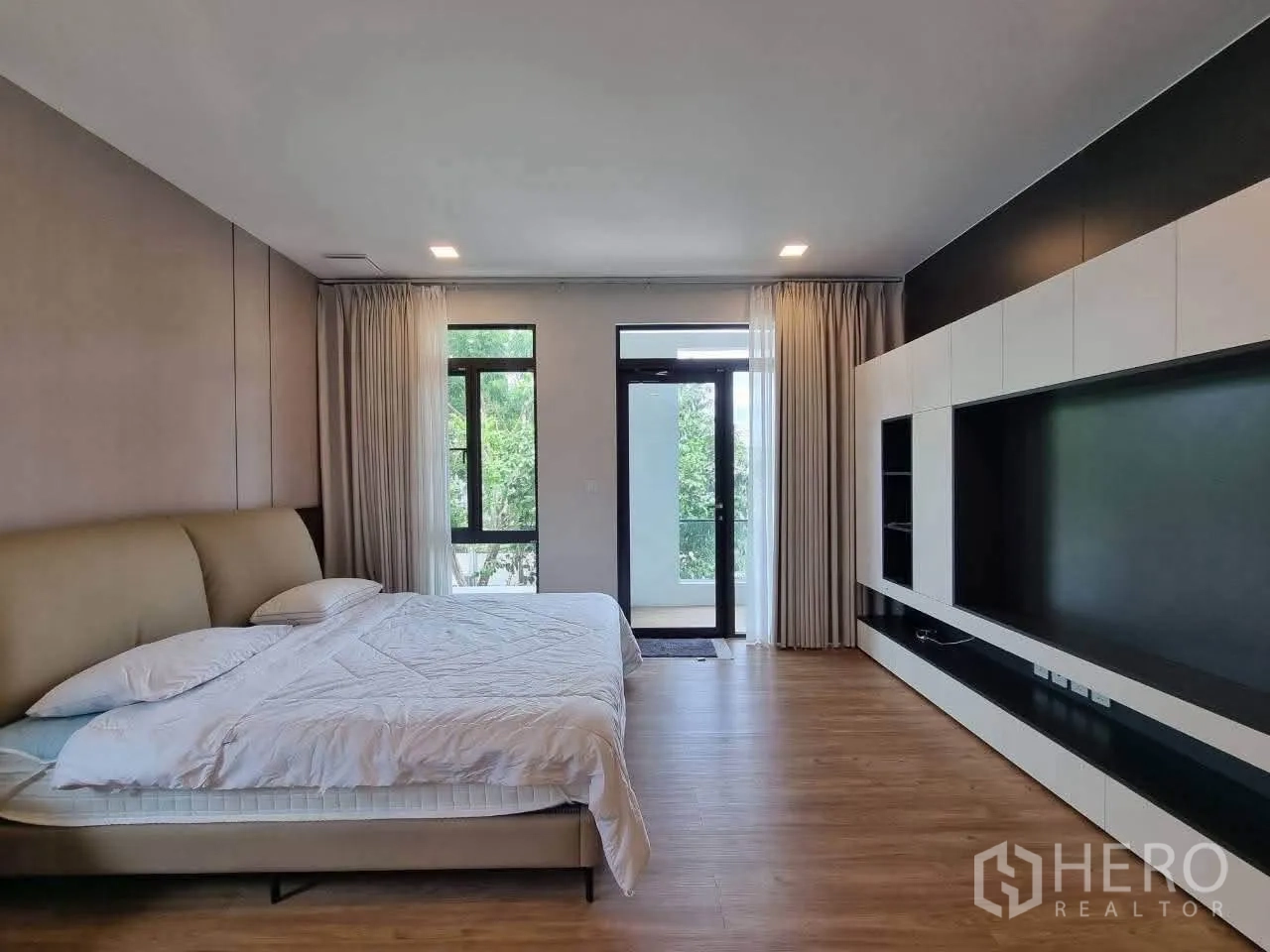 Detached House for rent in Bang Phli, Samut Prakan - Spacious primary bedroom with built-in media wall and access to balcony.