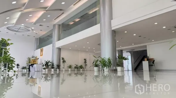 零售空间 出租在Huai Khwang, Bangkok - 展厅带夹层玻璃栏杆与银色立柱，地面宽敞，布局灵活。