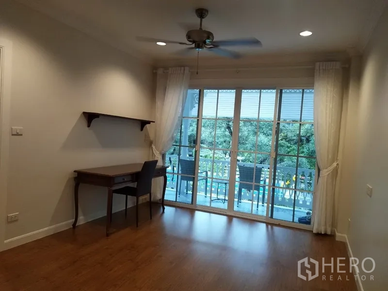 联排别墅 出租在Mueang Samut Prakan, Samut Prakan - 多功能房，书桌、吊扇，宽幅玻璃门通阳台。