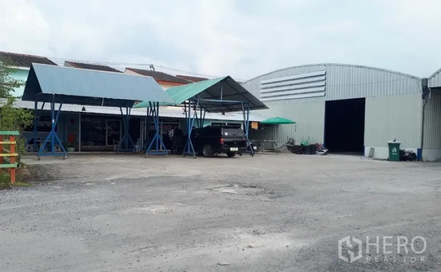 Warehouse for rent in Nong Chok, Bangkok - Exterior view of the warehouse compound with metal sheds, parking area and main loading entrance.