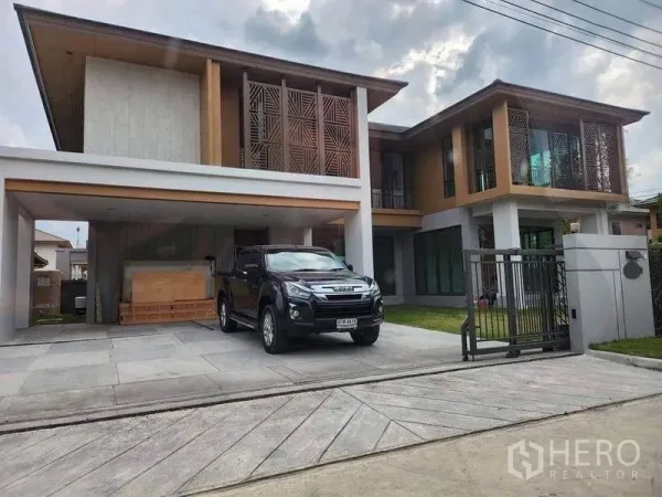 บ้าน ขายในSai Mai, Bangkok - ด้านหน้าบ้านเดี่ยวสองชั้น หน้ากากไม้ระแนง ประตูรั้วและที่จอดรถในร่มสองคัน