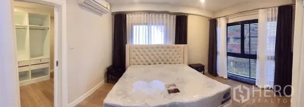 联排别墅 出租在Khlong Toei, Bangkok - 采光充足的主卧，软包床头，阳台移门与步入式衣帽间。