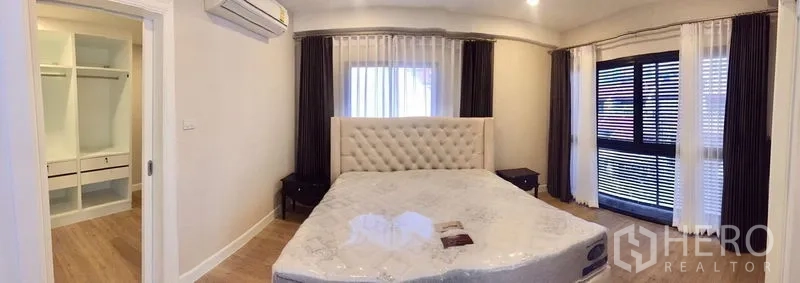 联排别墅 出租在Khlong Toei, Bangkok - 采光充足的主卧，软包床头，阳台移门与步入式衣帽间。