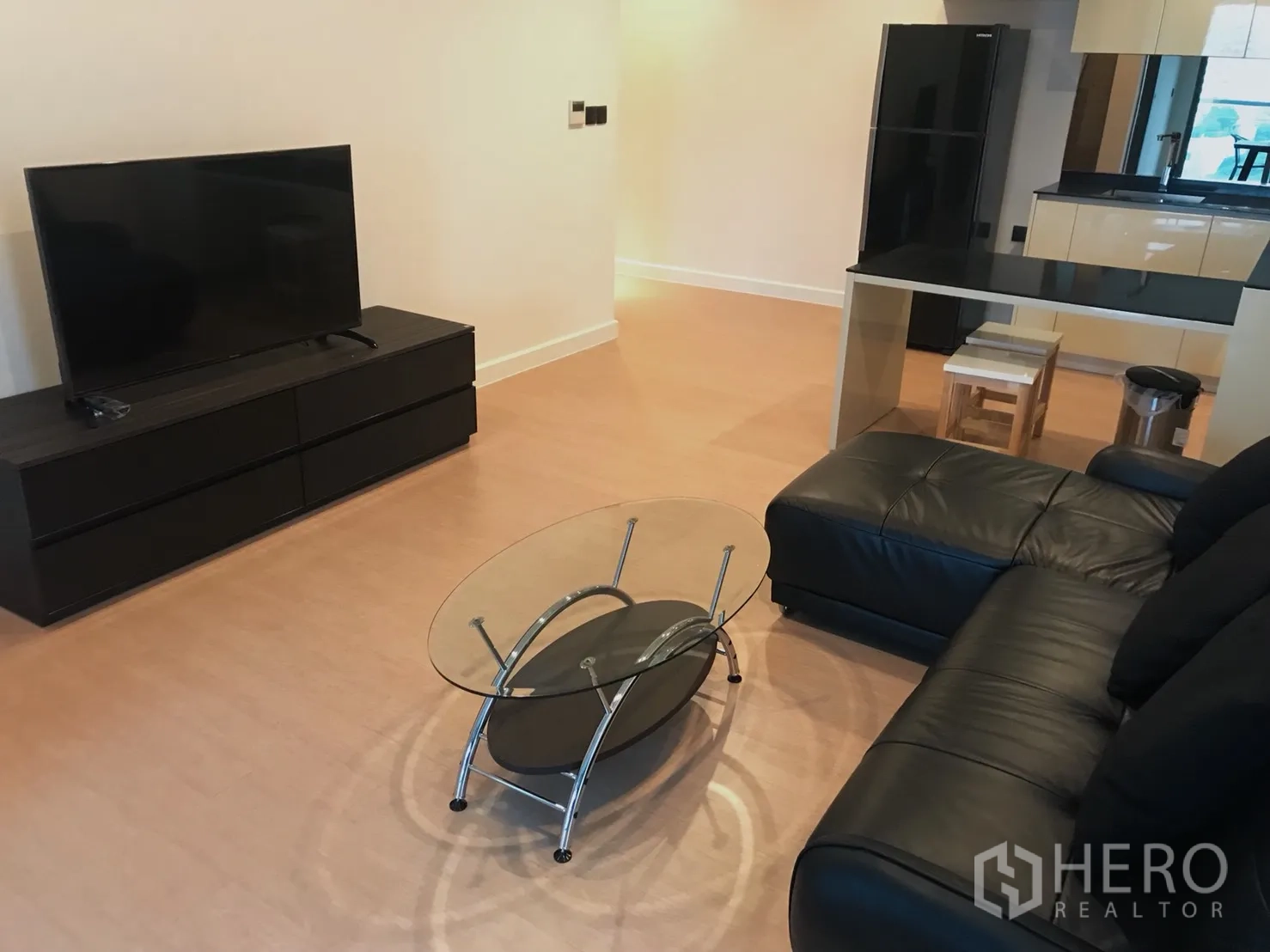 公寓 出租或出售在Bang Rak, Bangkok - 明亮客厅，黑色皮沙发、电视柜与玻璃茶几
