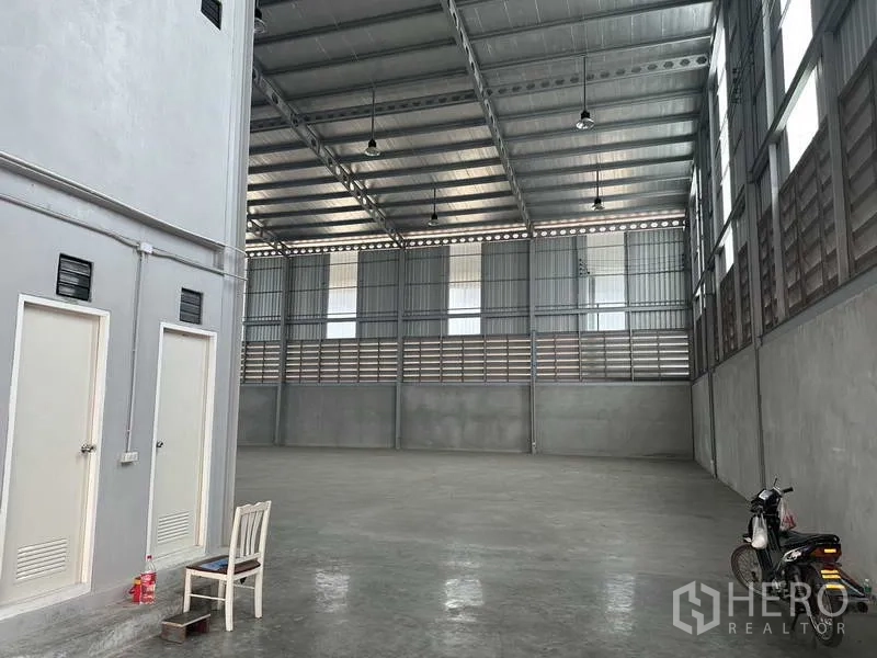 คลังสินค้า ให้เช่าในSamut Prakan - มุมภายในโกดังเห็นห้องน้ำและช่องระบายอากาศใต้โครงหลังคาเหล็ก.