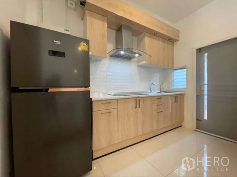 ทาวน์เฮาส์ ให้เช่าในPrawet, Bangkok - ครัวพร้อมตู้เย็น เครื่องดูดควัน และตู้ไม้กับผนังกระเบื้องขาว