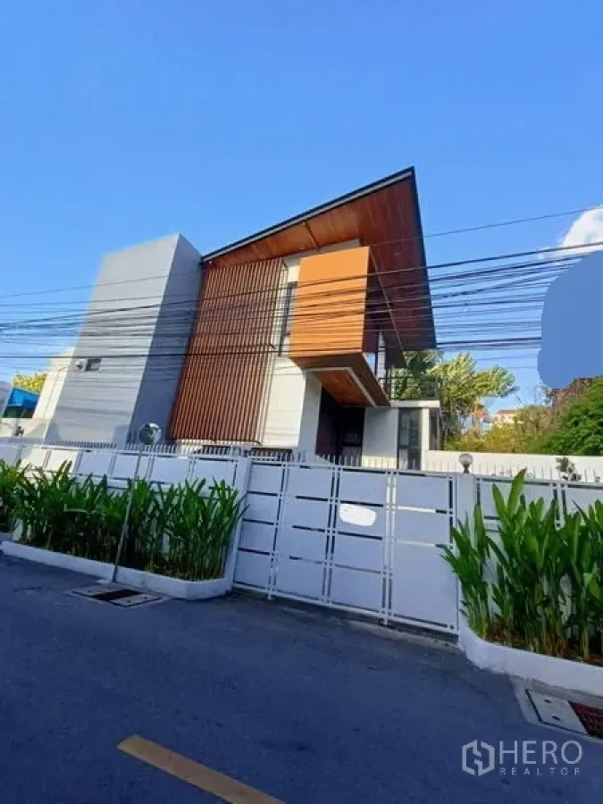 Home Office for rent in Watthana, Bangkok - Modern three-storey home office exterior with slanted roof and white gate in Watthana.