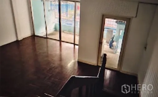 Home Office for rent in Khlong Toei, Bangkok - Upper-floor room with polished wood flooring and sliding glass doors opening to a balcony.