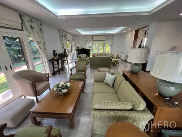 Detached House for rent in Bang Phli, Samut Prakan - Spacious living room with large windows, tray ceiling lighting, and garden views.