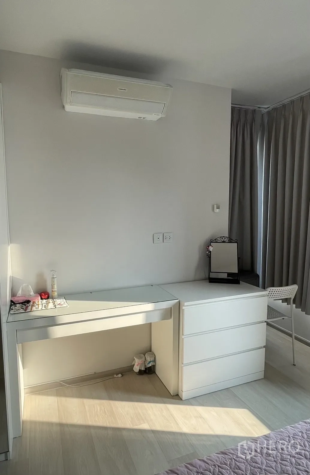 Condominium for rent in Pathum Wan, Bangkok - Bedroom work corner with desk, drawers and wall-mounted air conditioner.